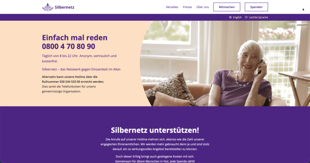 Webseite von Silbernetz mit Informationen zur kostenlosen Hotline „Einfach mal reden“, erreichbar unter 0800 4 70 80 90. Links steht der Hinweis auf tägliche Erreichbarkeit von 8 bis 22 Uhr. Rechts sitzt eine Person auf einem Sofa und hält ein Telefon ans Ohr. Darunter ein Abschnitt, der zur Unterstützung von Silbernetz aufruft.